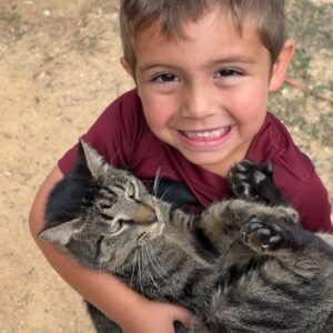 The kid with smilling face carrying cute little cat